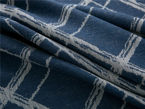 Macro shot showing weave texture of deep blue jacquard checkered fabric with white lines