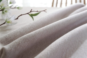 Close-up of beige faux linen tablecloth fabric showing cross-weave texture and soft drape