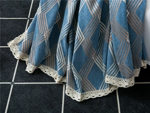 Detail of navy chenille sofa cover showing geometric patterns and white lace edges