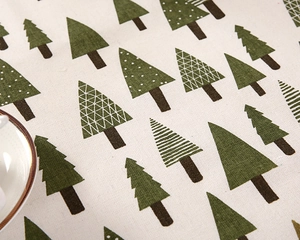 Close-up of cotton linen tablecloth with green geometric Christmas tree patterns