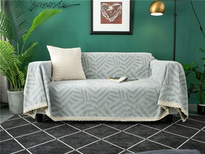 Detail of grey chenille sofa cover with square patterns and white lace trim edge