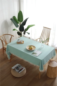Close-up of mint green rectangular tablecloth featuring elegant white tassel edges