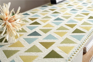Detailed view of chenille table runner with colorful geometric jacquard patterns