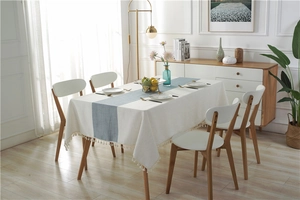Detail of waterproof dining table runner with blue geometric texture and white tassels