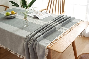 Detailed close-up of geometric striped tablecloth with cotton fringe tassels in Nordic style