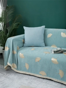 Close-up of chenille sofa cover with golden ginkgo leaves and delicate lace trim