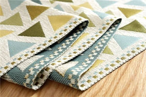 Detail of chenille table runner featuring geometric patterns and checkered border edges