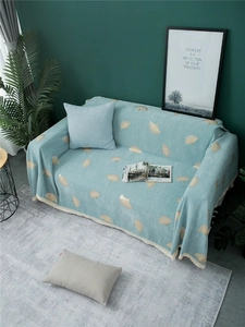 Detail of light blue chenille sofa cover with golden ginkgo leaves and lace edges