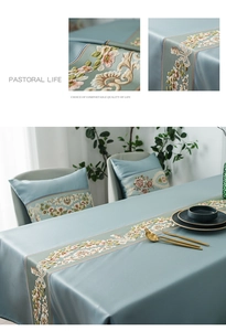 Detail of light blue tablecloth with floral embroidery and matching cushion set