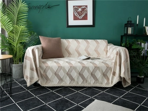 Detail of beige chenille sofa cover with brown geometric lines and delicate lace edges