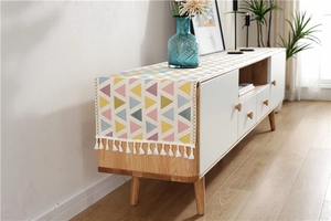 Macro detail of geometric triangle chenille runner with white tassel fringe accents