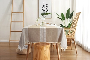 Detail of jacquard tablecloth with white geometric texture and small ball tassels decoration