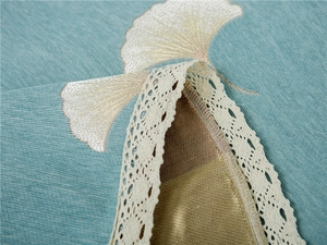Detailed close-up of chenille sofa cover with ginkgo embroidery and lace trim
