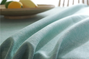 Detailed macro view of mint green faux linen tablecloth texture with rustic weave
