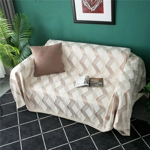 Thick chenille sofa cover with geometric patterns and lace trim in a modern living room