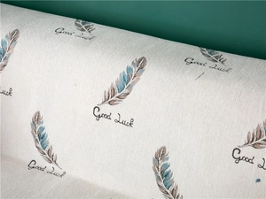 Detail of chenille sofa cover with knit feather patterns and Good Luck text embroidery