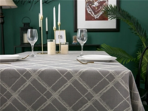 Detail of gray checkered tablecloth with white woven lines and elegant tassel fringe