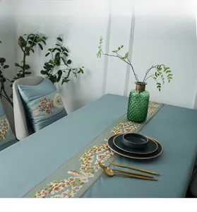 Detail view of luxury light blue table runner with elegant floral embroidery and thick texture