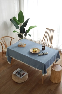 Detailed texture of navy blue tablecloth with elegant white fringe tassels and linen fabric