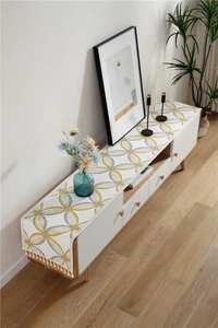 Detail of chenille table runner with geometric leaf pattern and decorative tassels