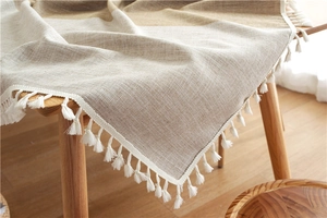 Close-up of Nordic style jacquard table runner with beige geometric pattern and white tassels