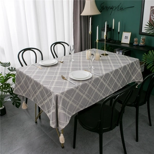 Detail of gray checkered tablecloth with white geometric lines and elegant fringe tassels