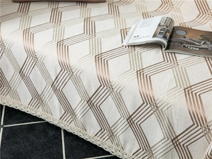 Close-up of chenille sofa cover with geometric patterns and elegant white lace edges