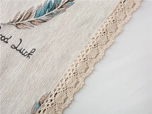 Close-up of thick chenille fabric featuring feather print and vintage lace edges