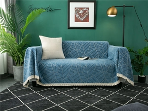Close-up of blue geometric chenille sofa cover with intricate white crochet lace trim