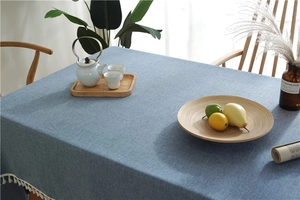Close-up of navy blue linen tablecloth featuring elegant white tassel lace edges