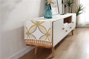 Close-up of chenille table runner with yellow grey leaf pattern and white tassels