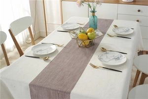 Detail of waterproof linen table runner with chevron pattern and beige tassel tablecloth