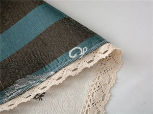 Close-up of thick chenille sofa cover with stripe pattern and lace embroidery edge