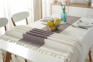 Detail of waterproof modern minimalist table runner with textured fabric and tassels