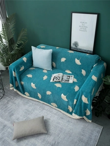 Detailed view of the dark teal chenille sofa cover with white ginkgo leaf pattern and lace trim