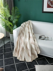 Close-up of thick chenille sofa cover with brown geometric wave lines and lace trim edge