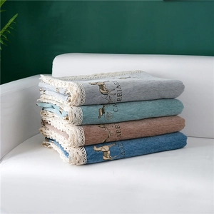 Close-up of stacked thick chenille sofa covers with lace trim and carriage pattern