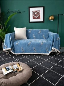 Detail of blue chenille sofa cover with feather prints and elegant lace border trimming