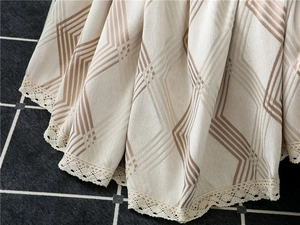 Close-up of thick chenille sofa cover with geometric diamond patterns and lace edges
