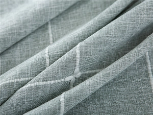 Detailed close-up of blue-grey jacquard fabric texture with white geometric cross-stitching