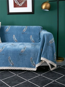 Detail of blue chenille sofa cover with feather pattern, good luck text, and lace edging