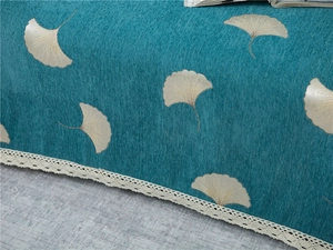 Detail of teal chenille sofa cover with yellow ginkgo leaves and white lace edging