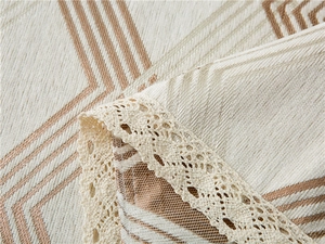 Detail of chenille sofa cover with geometric patterns and elegant lace border trimming