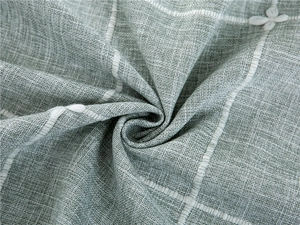 Macro detail of sage green polyester jacquard tablecloth with white floral embroidery