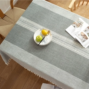 Blue-gray jacquard table runner with geometric textures and white cotton tassels