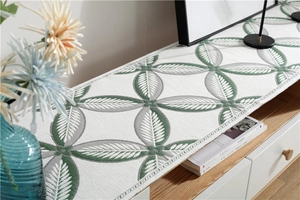 Detail of chenille table runner with green leaf pattern and decorative tassels