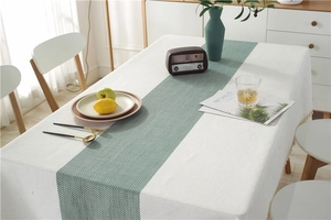 Detail of waterproof linen table runner with green herringbone pattern and fringe tassels