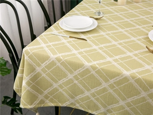 Detail of yellow and white lattice tablecloth with decorative fringe tassels and linen texture