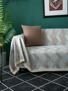 Detail of grey chenille sofa cover with geometric lines and delicate white lace edges