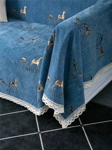 Detail of blue chenille sofa cover featuring carriage print and white crochet lace edges